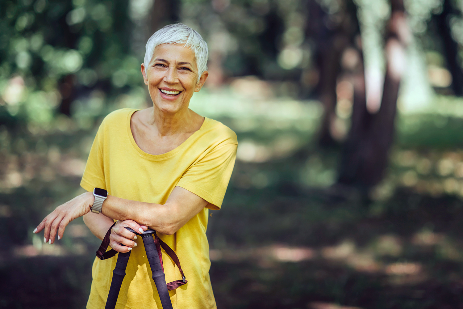 Seniorin macht Walking-Pause im Wald
